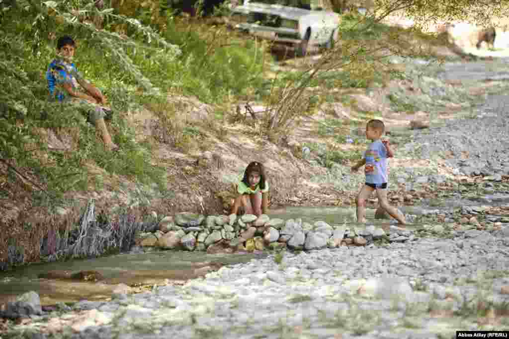 Uşaqlar arxın qarşısını çimmək üçün kəsirlər.