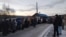 Residents of the remote Siberian town of Tura wait in line outside a food store. The "Z" symbol on the vehicle is a sign of support for Russia's war against Ukraine.