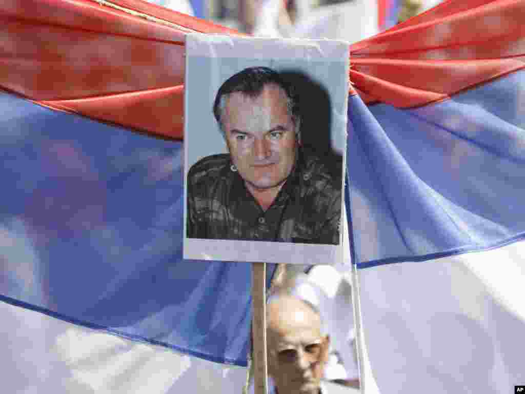 A man chants slogans while holding a flag and a photos of Ratko Mladic in Banja Luka. More than 10,000 people gathered in the city center of the Republika Srpska's capital to show their support for Mladic on May 31. AP photo by Amel Emric