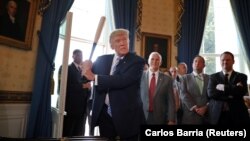 Дональд Трамп с бейсбольной битой на выставке продуктов "Сделано в Америке" в Белом доме 17 июля 2017 года