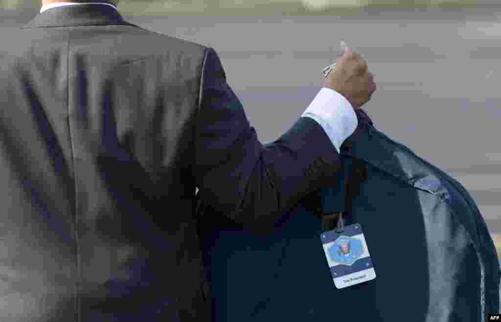 An aide to U.S. President Barack Obama carries the president's suit bag upon arrival in Chicago. (AFP/Saul Loeb)