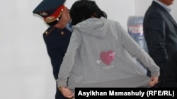 Проверка гражданки, которая идет в зал суда по событиям в Шетпе. Актау, 23 апреля 2012 года.