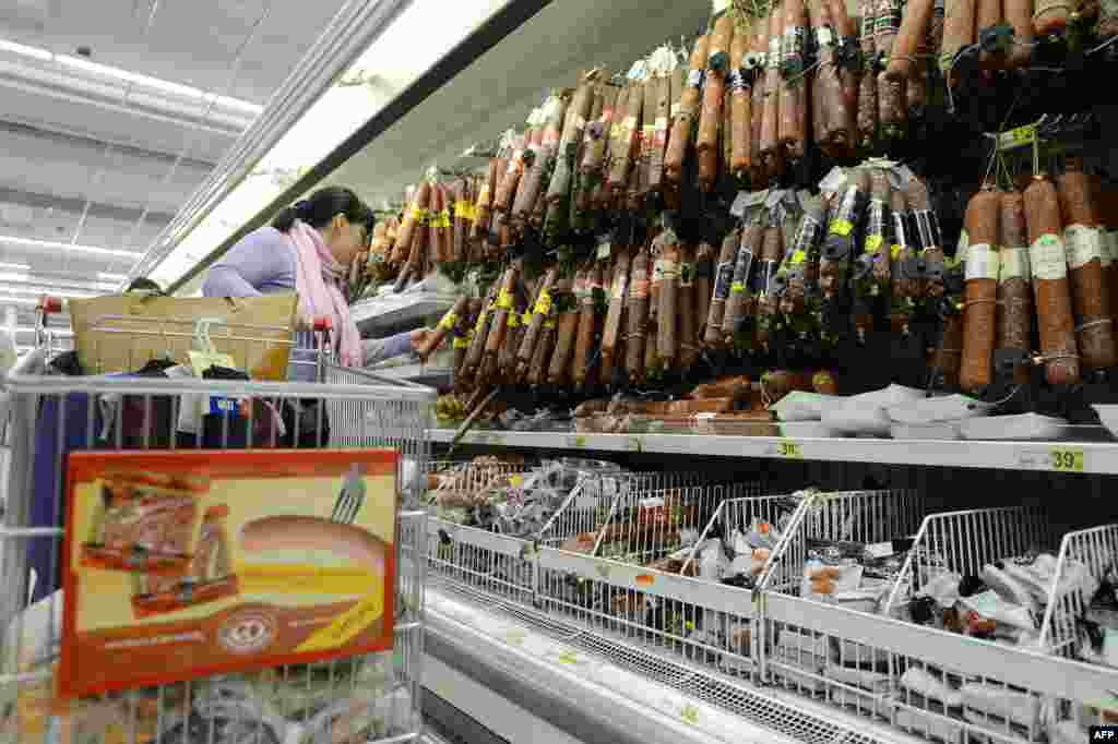 A customer compares smoked sausages in a Moscow hypermarket.