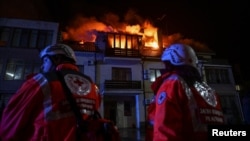 Red Cross emergency workers stand by an apartment building hit by a Russian drone strike in Zaporizhzhya, Ukraine, on March 1.