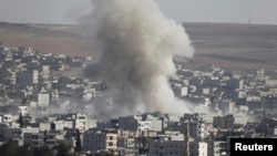 Smoke rises after a U.S.-led air strike on Islamic State positions in the Syrian town of Kobani on October 10.