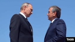 Then-Uzbek Prime Minister Shavkat Mirziyaev (right) speaks with Russian President Vladimir Putin after laying flowers at the grave of late Uzbek President Islam Karimov in Samarkand on September 6.