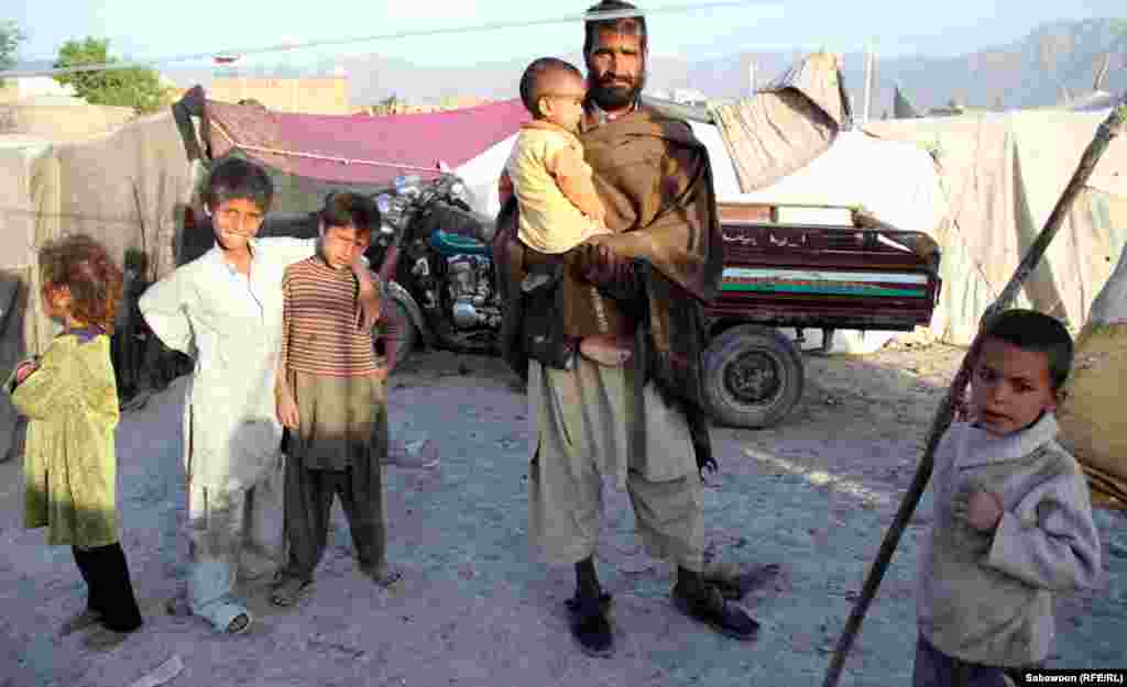 Afghanistan-Kabul International Children's Day 2012: Afghan family members stand with their Children at a shelter in Kabul.