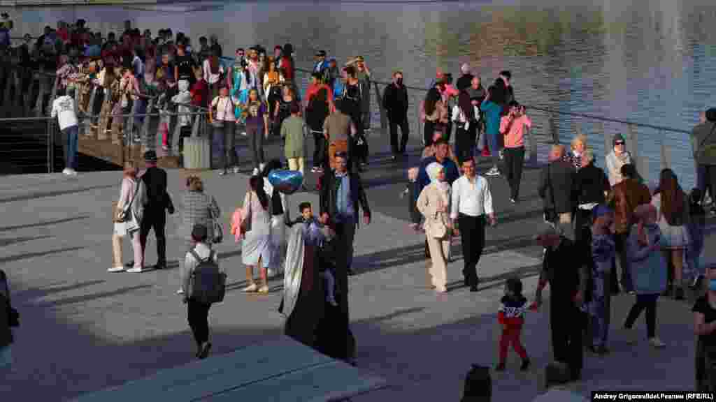 People walk along the embankment during the festivities.