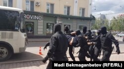 Полиция көшеден ұстаған адамды көлікке салып жатыр. Астана, 23 маусым 2018 жыл.