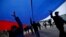 People march on the street with a giant Russian flag in Simferopol, Crimea.