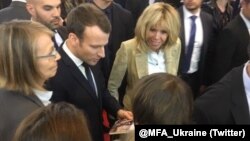 Ірена Карпа вручає Еммануелю Макрону книгу оповідань Олега Сенцова. Париж, 16 березня 2018 року