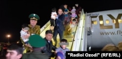 A plane filled with Tajik children turning from Iraq lands in Dushanbe. (file photo)