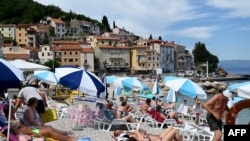 Ljudi na plaži u Mošćeničkoj dragi, u blizini zapadnog hrvatskog grada Rijeke, na Jadranskom moru, 10.
srpanj 2020. 