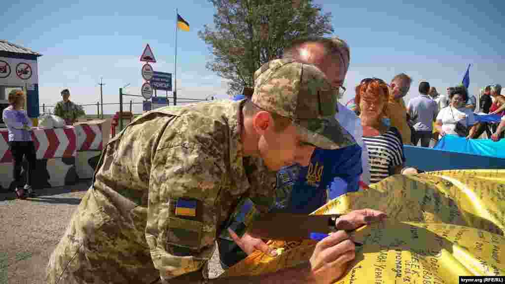 Участники мероприятия оставили свои пожелания на флагах, подписи поставили также представители Национальной полиции и Госпогранслужбы Украины
