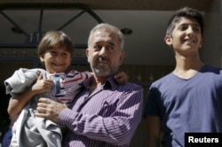 Абдель Мохсен с сыном Саидом на руках и старшим сыном Мохаммадом на новом месте жительства в испанском городе Хетафе