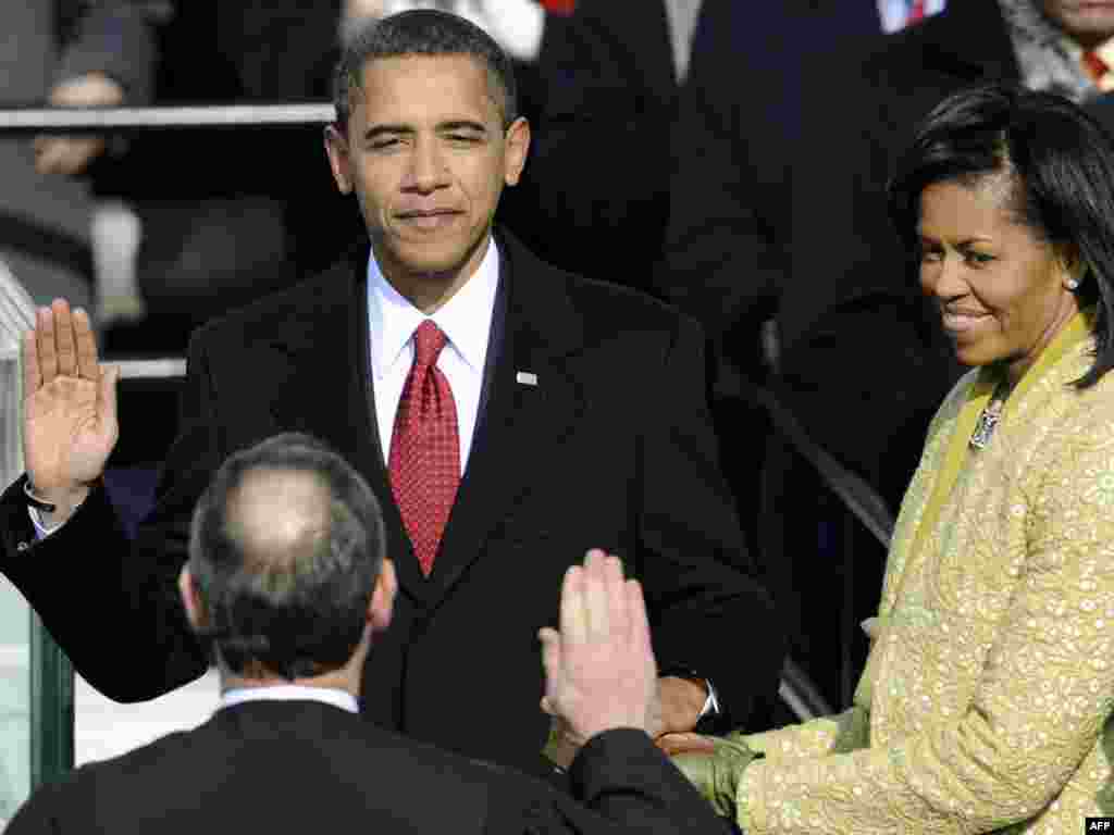 Барак Обаманы Жогорку Соттун төрагасы ант бердиртип жатат. - Barack Obama is sworn in as the 44th US president by Supreme Court Chief Justice John Roberts in front of the Capitol in Washington on January 20, 2009. Michelle Obama (R) holds the Lincoln Bible. top2009 obama20