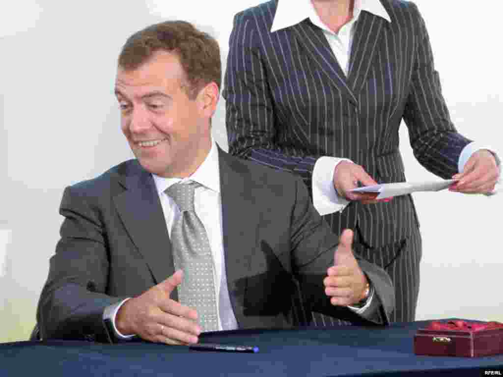 Дмитрий Медведев гасит юбилейные марки во время церемонии открытия выставки