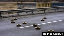 Harckocsi elleni aknák egy bucsai hídon Kijev közelében 2022. április 2-án
