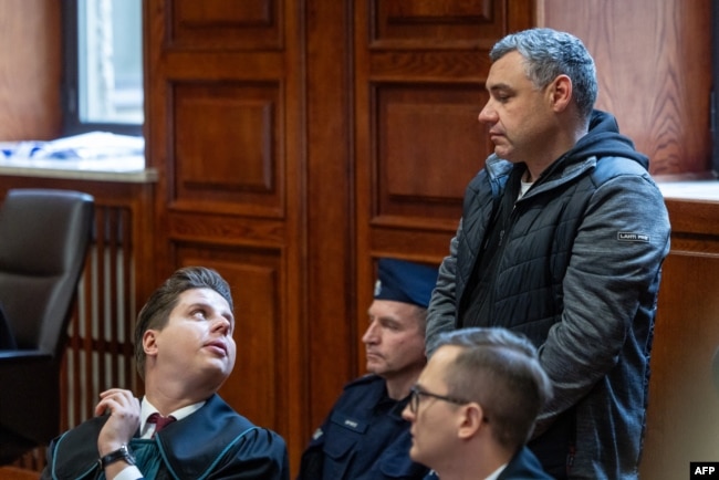 Обвинувачений громадянин України Володимир Журавльов (праворуч) стоїть поруч зі своїми адвокатами, поки суддя оголошує рішення про відмову в екстрадиції до Німеччини, у залі засідань Окружного суду Варшави, Польща, 17 жовтня 2025 року