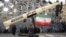 Iranians stand next to a mockup of a Kheibar missile in Tehran amid a fragile cease-fire in the Middle East. 