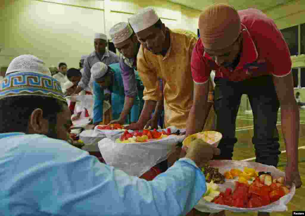 RELIGION-RAMADAN/ Singapore -- Bangladeshi workers prepare to break fast during the holy month of Ramadan at a makeshift mosque near their dormitory in Singapore June 18, 2015