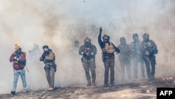 Федерални агенти на имиграционната служба на САЩ обстрелват със сълзотворен газ протестиращи в Минеаполис след убийството на Алекс Прети, застрелян от техни колеги часове по-рано, 24 януари 2026 г. 