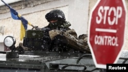 Российский военнослужащий около украинской военной базы в крымском селе Перевальное, 16 марта 2014 года