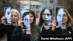Disa aktiviste për të drejtat e grave mbajnë në duar fotografi të viktimave të dhunës në familje. Foto nga arkivi. 