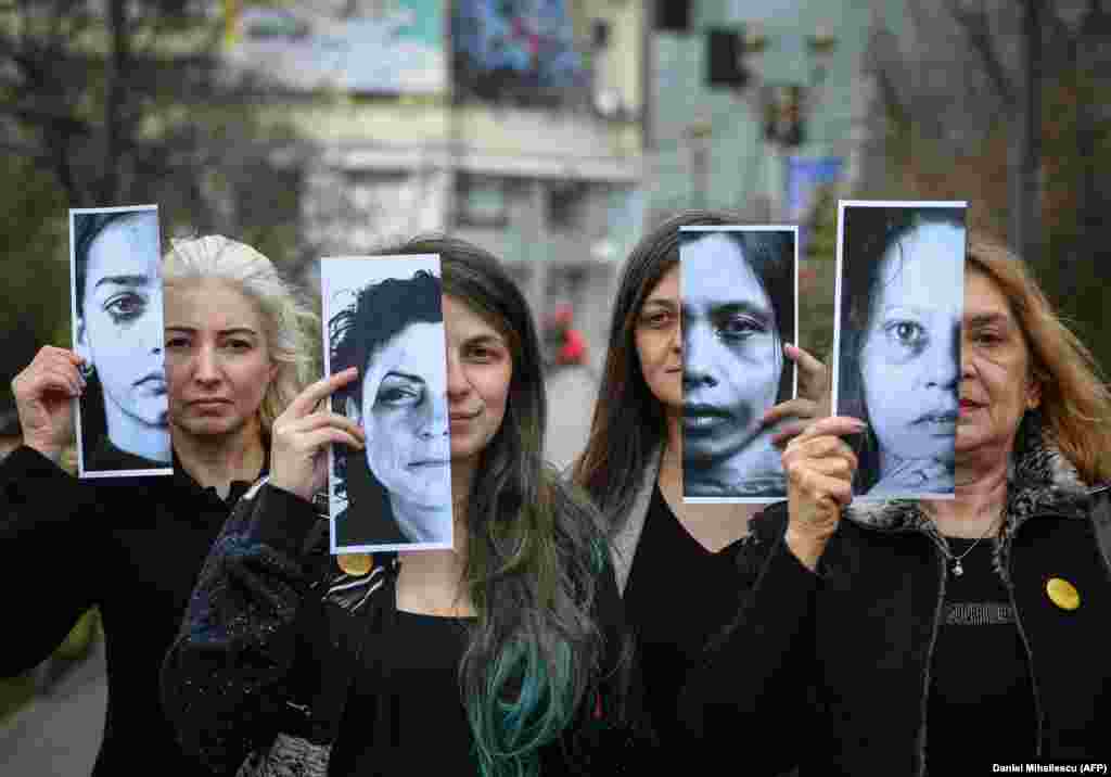 Activists of the Declic movement for women&#39;s rights hold printed half-face pictures showing victims of domestic violence during a protest in Bucharest on March 4. (AFP/Daniel Mihailescu)