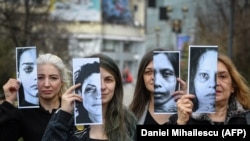 Disa aktiviste mbajnë në duar portretet e viktimave të dhunës në familje. Foto nga arkivi. 