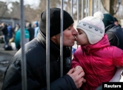 A father kisses his daughter after a ceremony marking enrollment for new conscripts in the Ukrainian Army in Kyiv in January.