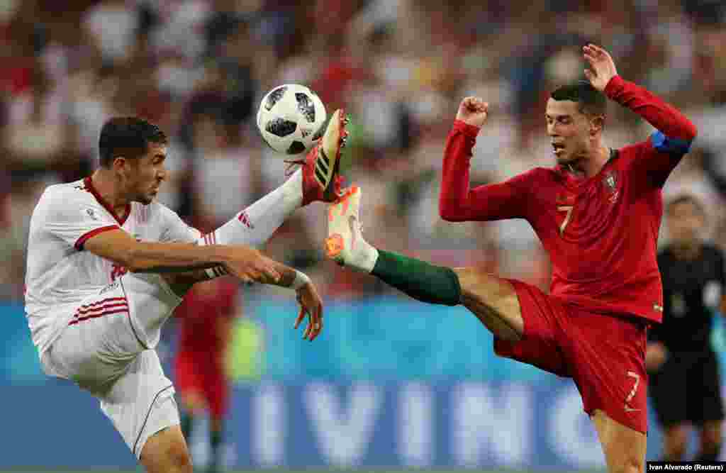 Iran's Majid Hosseini (left) competes for the ball with Portugal's Cristiano Ronaldo in their countries' World Cup group game in Saransk, Russia, on June 25. (Reuters/Ivan Alvarado)