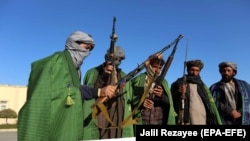 FILE: Former Taliban members surrender their weapons during a ceremony marking their reconciliation with the government in Herat on November 15.