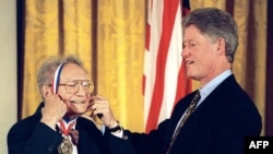 پل ساموئلسون در حال دریافت مدال ملی علوم امریکا از دست بیل کلینتون، رئیس جمهور وقت آمریکا، در سال ۱۹۹۶ 