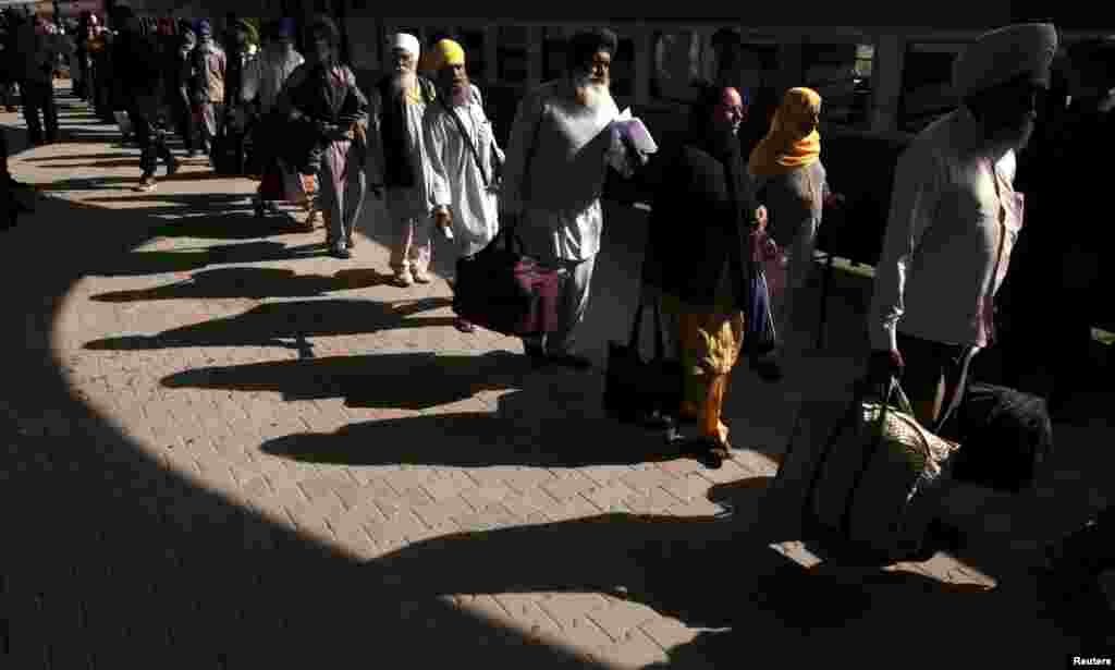 Indian Sikh pilgrims arrive at the Wagah border railway station to attend the 546th birth celebrations of Sikh founder Guru Nanak Dev Ji in Lahore, Pakistan. (Reuters/Mohsin Raza)