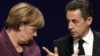 French President Nicolas Sarkozy (right) and German Chancellor Angela Merkel following crisis talks with Greek Prime Minister George Papandreou in Cannes.