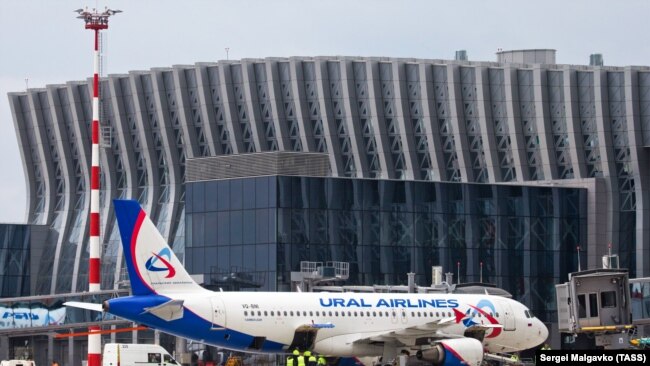Самолет авиакомпании «Уральские авиалинии» на фоне аэропорта в Симферополе