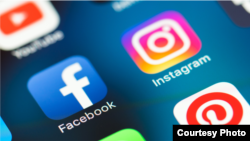Иконки мобильных приложений Facebook и Instagram на дисплее смартфона