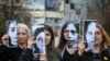 Disa aktiviste mbajnë në duar portretet e viktimave të dhunës në familje. Foto nga arkivi. 