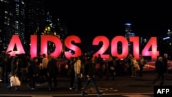 Australia -- People gather next to a sign reading AIDS 2014 in Melbourne, July 18, 2014