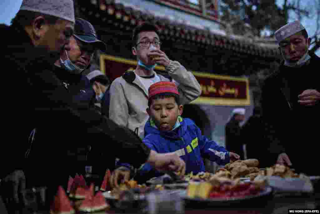 Муслимани како јадат пред првиот ден од постот месец Рамазан во џамијата Ниуџи во градот Пекинг, Кина, 13 април 2021 година.
