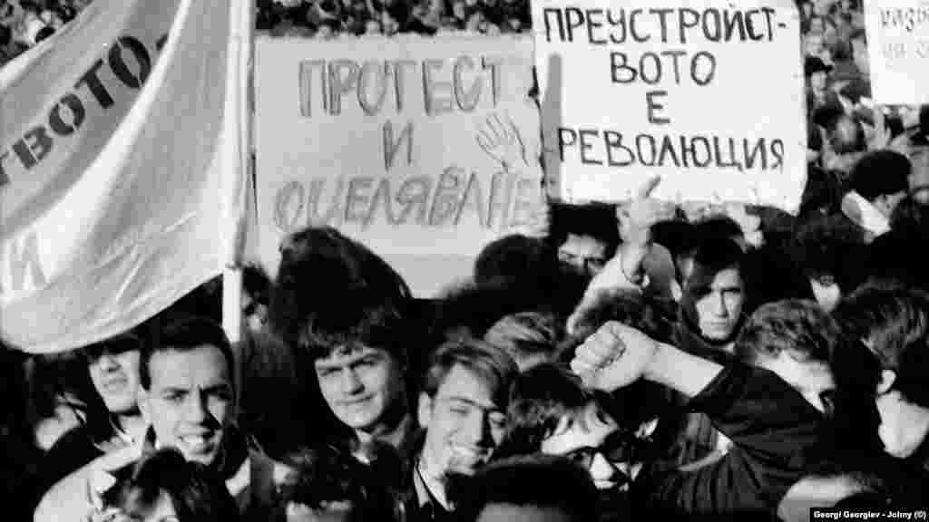 Емоциите се отпушват чак на осмия ден, 18.11.1989 г. Тогава опозицията провежда първия си митинг - пред Св. &quot;Александър Невски&quot;. Тогава тя не се нарича &quot;опозиция&quot;, изразът е &quot;неформални сдружения&quot;. Хората отиват на митинга с разнородни и понякога несъвместими лозунги и искания. Част от плакатите отразяват тогавашната нагласа на много участници, че в България ще започне да се извършва преустройство, каквото протича в СССР от няколко години.