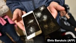 Migrant iz Afganistana pokazuje mobitele uništene prilikom nasilnog vraćanja iz Hrvatske u BiH, u selu Bosanska Bojna, uz granicu Hrvatske i BiH, siječanj 2021.