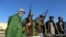 FILE: Former Taliban members surrender their weapons during a ceremony marking their reconciliation with the government in Herat on November 15.