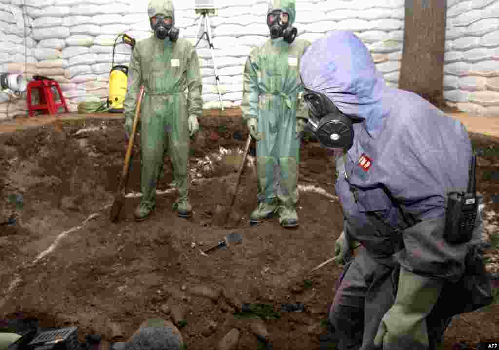 A Chinese chemical-weapons disposal team excavates chemical bombs from a site near a school in the northeastern Chinese city of Mudanjiang in 2006. Japananese soldiers left hundreds of thousands of mustard-gas bombs and other such weapons in China at the end of World War II. It is considered the world&#39;s largest stockpile of abandoned chemical weapons. 