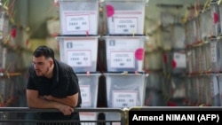 Službenik Centralne izborne komisije pored kutija sa glasačkim listićima u centru za brojanje u Prištini, 24. januara 2026.