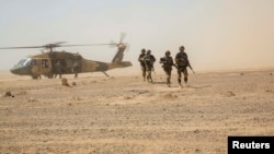 Afghan troops disembark an Afghan Air Force Black Hawk helicopter at Camp Shorabak in Helmand Province. The air force, SIGAR's report noted, is now increasingly overstretched.