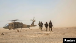 Trupat e Korpusit 215 të Ushtrisë Kombëtare të Afganistanit zbarkojnë me një helikopter Black Hawk të Forcave Ajrore Afgane, gjatë një rifurnizimi të trupave në kampin Shorabak në provincën Helmand. 28 korrik 2018.