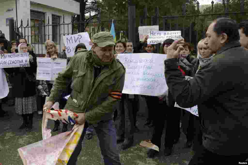 Aqmescitte çarşenbe künü martnıñ beşinde genç qızlar Ukraina Silâlı Quvetleriniñ arbiy hızmetçilerine Ukraina Arbiy-deñiz quvetleri yalı mudafaa ordularınıñ ştabı yanında qol tutuv numayışına çıqtılar