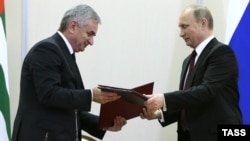  Abkhazian leader Raul Khajimba (left) and Russian President Vladimir Putin exchange documents during the signing ceremony at the Bocharov Ruchei residence in Sochi on November 24.